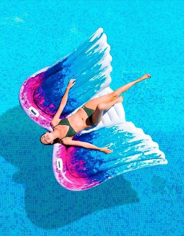 A person holding the Intex inflatable Angel Wings raft to show its size.